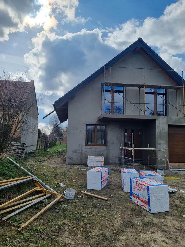 Front domu podczas ocieplania i tynkowania